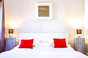 波尔多Sainte Catherine - Duplex 1 chambre的卧室配有带红色枕头的白色床
