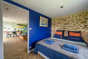 普罗梅尔Les gîtes d'Izel RDC的一间卧室拥有蓝色的墙壁,配有一张带蓝色枕头的床。