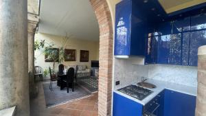 费拉拉Vizi e Virtù的一间设有蓝色橱柜的厨房和一间客厅