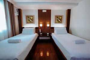 黎牙实比埃默拉尔德精品酒店的小客房内的两张床,配有白色床单