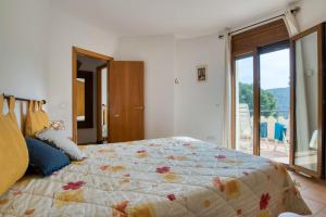 巴古尔BEGUR-SA RIERA 156的一间卧室设有一张大床和一个大窗户