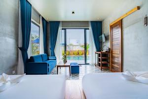 贡布Kampot Sweet Boutique的酒店客房,设有两张床和一张蓝色的沙发