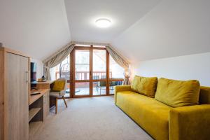 索瓦塔Pensiunea Comfort的客厅配有黄色沙发和书桌