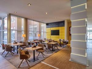 科隆科隆瑟夫灵霍夫美居酒店的用餐室设有桌椅和窗户。