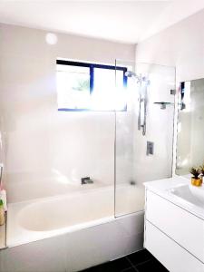 GlenfieldLovely Queen Room + TV +Wifi FREE Parking Pet Friendly的白色的浴室设有浴缸和水槽。