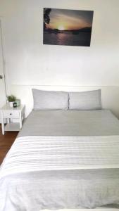 GlenfieldLovely Queen Room + TV +Wifi FREE Parking Pet Friendly的卧室配有一张白色床,墙上挂着一幅画