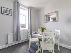 BedlingtonLilys Apartment 2- 2bedroom, Northumberland的白色的用餐室配有白色的桌椅
