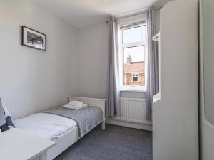 BedlingtonLilys Apartment 2- 2bedroom, Northumberland的一间小卧室,配有床和窗户