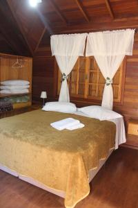 卡内拉Pousada Floresta Negra的一间卧室配有一张床,上面有两条毛巾