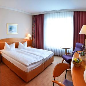 梅拉内Hotel Meerane的酒店客房带一张大床和一把椅子