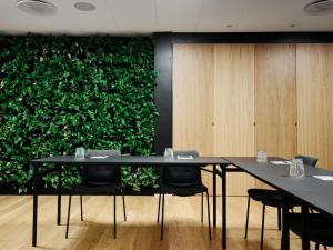 奥胡斯奥胡斯市奥西亚酒店的一间会议室,配有两张桌子和绿色的墙壁
