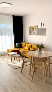 格但斯克Przystań Letników by MYPART in your apartment的客厅配有黄色的沙发和桌子
