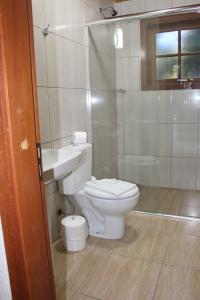 卡内拉Pousada Floresta Negra的浴室配有卫生间、盥洗盆和淋浴。