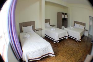 沙佩科Hotel Condá的带两张床和镜子的客房