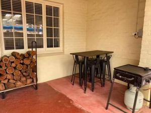 诺瑟姆Avon Homestay的一间设有两张桌子、一个烧烤架和木柴的房间
