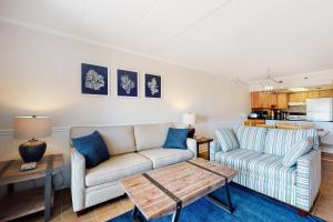 大洋城Sandpiper Dunes 105的客厅配有沙发和桌子