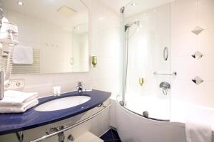 因斯布鲁克蒙德施恩酒店的一间带水槽和淋浴的浴室