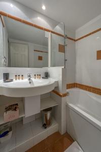 居让梅斯特拉Appartement Pheonix YourHostHelper的一间带水槽、浴缸和镜子的浴室