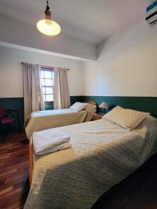 罗萨里奥Chalet de las Tejas的一间卧室设有两张床和窗户。