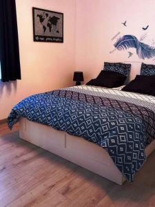 WattenLe Watt'else的一间卧室配有一张带蓝色和白色棉被的床