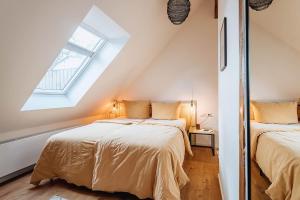 罗斯托克Apartments Kassebohmer Weg的阁楼卧室设有两张床,配有窗户