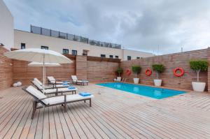 休达休达普尔塔非洲酒店的一个带椅子和遮阳伞的庭院和一个游泳池