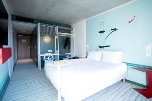 勒图凯-巴黎普拉日Ibis Styles Le Touquet的卧室配有白色的床和蓝色的墙壁