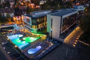 弗尔尼亚奇卡矿泉镇Hotel Tonanti的一座建筑,在晚上前方有一个游泳池