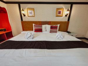 清迈Hotel De Khuvieng的卧室配有带毛巾的大型白色床