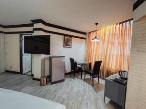 清迈Hotel De Khuvieng的酒店客房设有餐桌和电视。