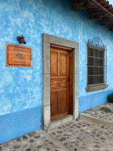科潘玛雅遗址Hostel Iguana Azul的蓝色的建筑,设有木门和钟