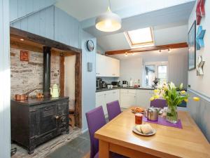 廷塔杰尔Mews Cottage的厨房配有木桌和炉灶。