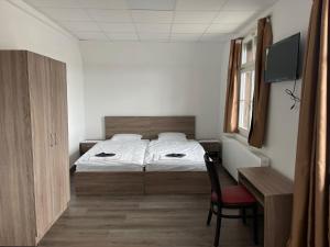 HerzogenbuchseeHotel da Luca的一间卧室配有一张床、一把椅子和一张书桌