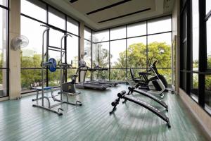 Ban RangengPark Town Residence的健身房设有数台有氧运动器材和大窗户