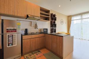 Ban RangengPark Town Residence的厨房配有木制橱柜和冰箱。