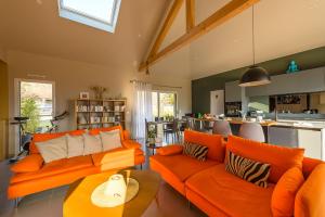 圣若里奥Charmante maison avec Vue LAC et Montagnes - PISCINE privative - LLA Selections by Location lac Annecy的一间带橙色沙发的客厅和一间厨房