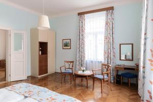 布拉格Sibelius Apartments的卧室配有一张床和一张桌子及椅子