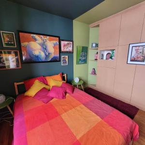 AndrimontL'Atelier Bed and Breakfast的一间卧室配有一张带彩色毯子的床