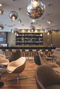 曼彻斯特曼彻斯特皮卡迪利汽车旅馆一号的一间品酒室,内设带椅子和灯的酒吧