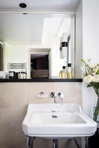 巴黎Holiday Inn Paris Elysées, an IHG Hotel的浴室设有白色水槽和镜子
