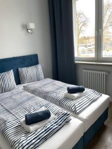 埃尔布隆格Aparthotel Dworzec的卧室内的两张床和毛巾