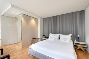 布拉加Sé Apartamentos - Sé INN Studios的卧室配有白色大床和白色枕头