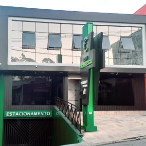 科蒂亚HOTEL CUCA FRESCA - COTIA的前面有绿色标志的建筑