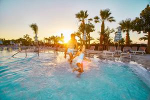坎波菲利斯·迪·罗切Grand Palladium Sicilia Resort & Spa的男人和女人在游泳池玩耍