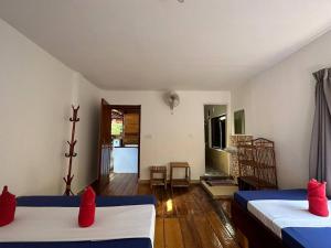 瓜隆岛快乐大象简易别墅酒店的客房 - 带两张带红色枕头的床