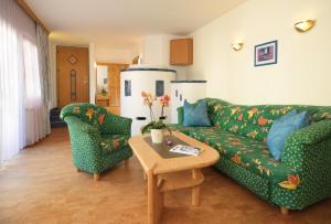 因斯布鲁克斯切福勒酒店的客厅配有绿色沙发和两把椅子