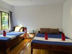 瓜隆岛快乐大象简易别墅酒店的宿舍间内的两张床,配有红色枕头
