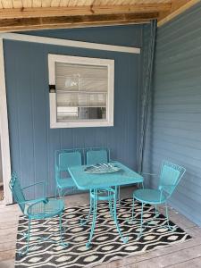 圣奥古斯丁The Painted Lady, a spacious renovated 4BR Victorian的门廊上的蓝色桌子和椅子,配有桌子