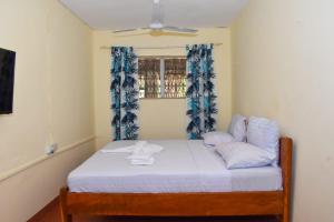 迪亚尼海滩Double room in a villa的一间卧室配有一张带白色床单的床和一扇窗户。