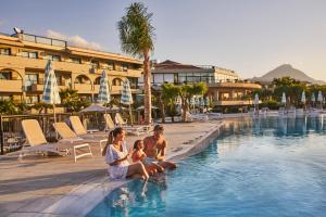 坎波菲利斯·迪·罗切Grand Palladium Sicilia Resort & Spa的住在度假村游泳池里的家庭
